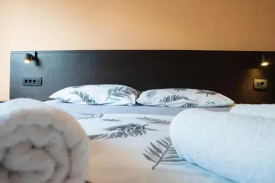a bed with two white pillows and a black headboard at Central Apartment Dobrota II in Kotor