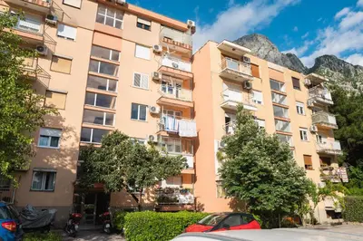 an apartment building in front of a mountain at Central Apartment Dobrota II in Kotor