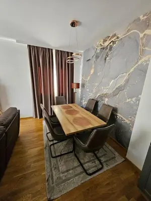 a dining room with a wooden table and chairs at Agape Bečići Apartment in Becici