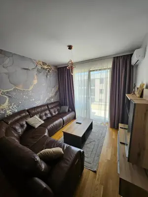a living room with a leather couch and a table at Agape Bečići Apartment in Becici
