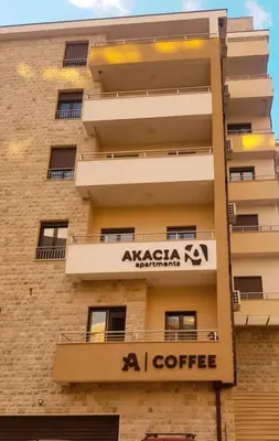an apartment building with a sign on the side of it at Apartman Dunja Bečići in Becici