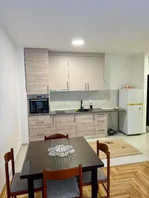 a kitchen with a table and chairs in a room at Apartman Dunja Bečići in Becici