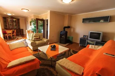 a living room with orange couches and a tv at Orange tree Residency in Bar