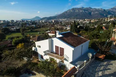 an aerial view of a white house with mountains in the background at Orange tree Residency in Bar