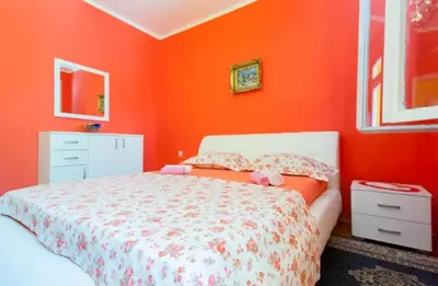 a bedroom with an orange wall with a bed at Stefanelo in Ulcinj