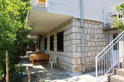 a building with a table and a bench next to it at Stefanelo in Ulcinj