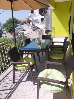 a table and chairs on a balcony with an umbrella at Stefanelo in Ulcinj