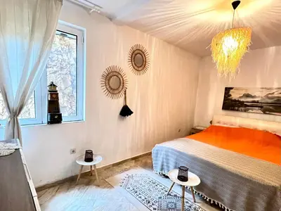a bedroom with a bed and a window and a chandelier at Hladna Uvala Apartment - 2 bedroom in Bar