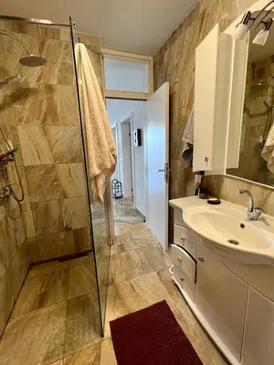 a bathroom with a shower and a sink and a mirror at Hladna Uvala Apartment - 2 bedroom in Bar