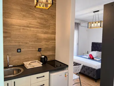 a kitchen with a sink and a bed in a room at Addy's Apartments in Ulcinj
