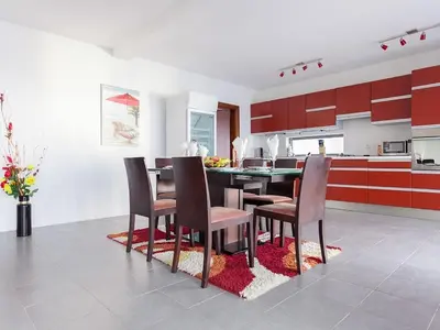 a kitchen with red cabinets and a table and chairs at Villa Infinity swimming pool above Saint Stephan in Andriči°i