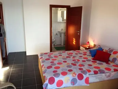 a bedroom with a bed with a flowered comforter at Villa Infinity swimming pool above Saint Stephan in Andriči°i