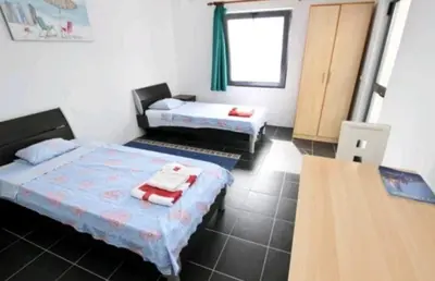 a room with two beds and a wooden table at Villa Infinity swimming pool above Saint Stephan in Andriči°i
