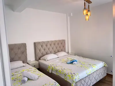 a bedroom with two beds and a mirror at Addy House in Ulcinj