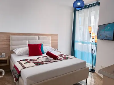 a bedroom with a large bed with red pillows at Addy House in Ulcinj