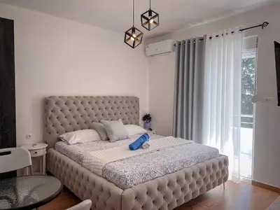 a bedroom with a large bed with a large window at Addy House in Ulcinj