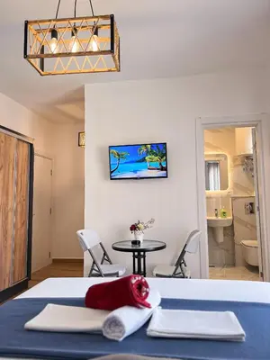 a room with a bed and a table and a bathroom at Addy House in Ulcinj