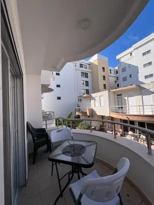 a balcony with a table and chairs on a building at Addy House in Ulcinj