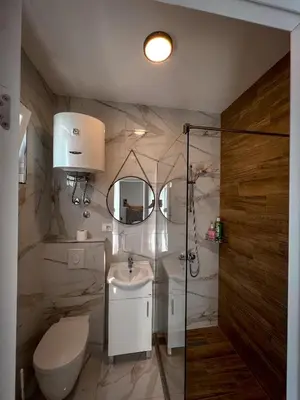 a bathroom with a sink and a toilet and a mirror at Addy House in Ulcinj