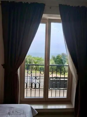 a bedroom with a window with a view of a balcony at Casa Oliva Apartments in Katun
