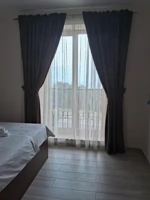 a bedroom with a bed and a large window at Casa Oliva Apartments in Katun