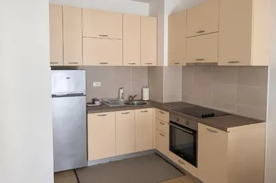 a kitchen with white cabinets and a refrigerator at Dagana in Budva