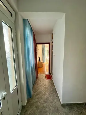 a hallway with blue curtains and a door with a doorway at Apartments Nera in Utjeha