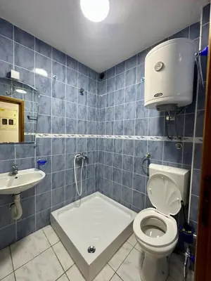 a blue tiled bathroom with a toilet and a sink at Apartments Nera in Utjeha