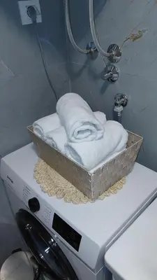 a basket of towels sitting on top of a washing machine at Apartman Vuk 15 in Budva