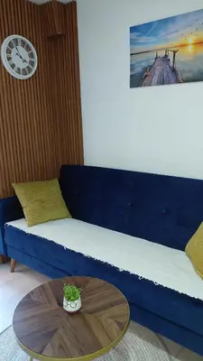 a blue couch with a table in a living room at Apartman Vuk 15 in Budva