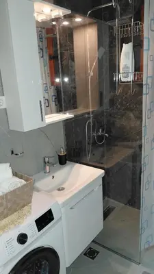 a bathroom with a washing machine and a shower at Apartman Vuk 15 in Budva