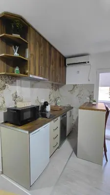 a kitchen with wooden cabinets and a black microwave at Apartman Vuk 15 in Budva