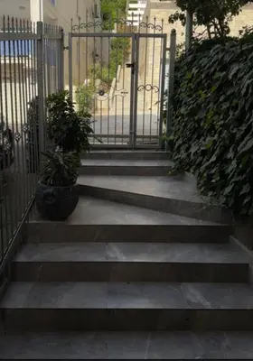 a set of stairs with a gate and a potted plant at Apartments Lipa in Budva