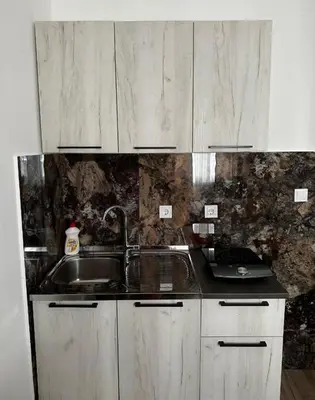 a kitchen with white cabinets and a sink at Apartments Lipa in Budva