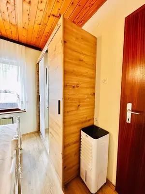 a room with a wooden wall with a door and a heater at Princess of the Beach in Sutomore