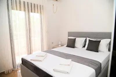 a bedroom with a large bed with a large window at Antonios Apartments in Ulcinj