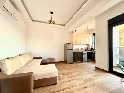 a living room with a couch and a kitchen at Veliki Pijesak One Bedroom Apartment in Dobra Voda