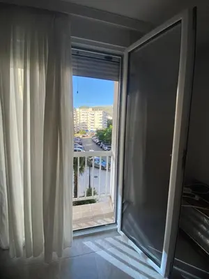 a room with a window with a view of a city at Centar, Kosta apartment in Bar