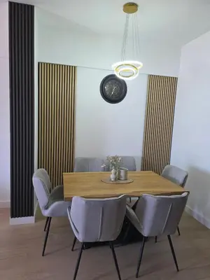 a dining room with a wooden table and chairs at Azure Elite Apartment in Becici