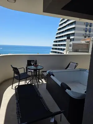 a balcony with a table and chairs and a view of the ocean at Azure Elite Apartment in Becici
