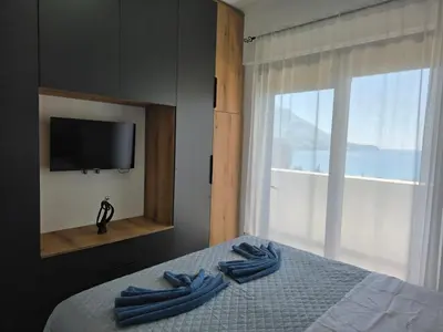 a bedroom with blue towels on a bed with a window at Azure Elite Apartment in Becici