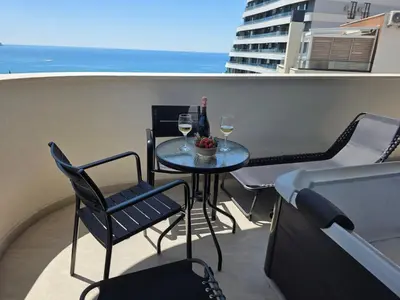 a balcony with a table and two glasses of wine at Azure Elite Apartment in Becici