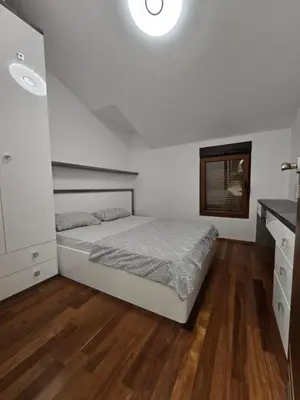 a bedroom with a bed and a wooden floor at Apartman Milunović in Dobrota