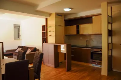 a kitchen and living room with a table and chairs at Andreja Apartment in Budva