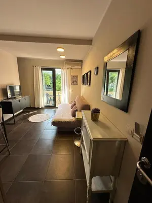 a living room with a couch and a mirror at Bono Apartments in Budva