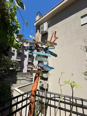 a pole with street signs in front of a building at Bono Apartments in Budva