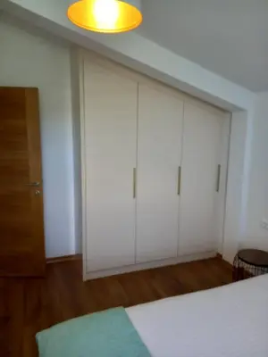 a bedroom with white cabinets and a bed at Apartman Borka Rezevici in Krstac