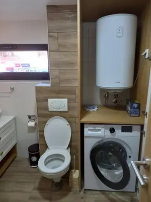 a small bathroom with a toilet and a washing machine at Apartman Borka Rezevici in Krstac