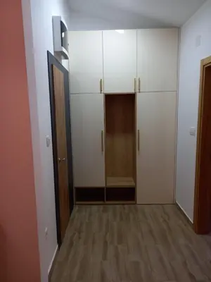 an empty room with white cabinets and a door at Apartman Borka Rezevici in Krstac