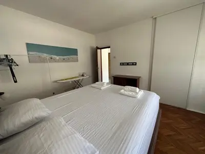 a white bedroom with two beds and a window at Apartment Mediteraneo in Budva